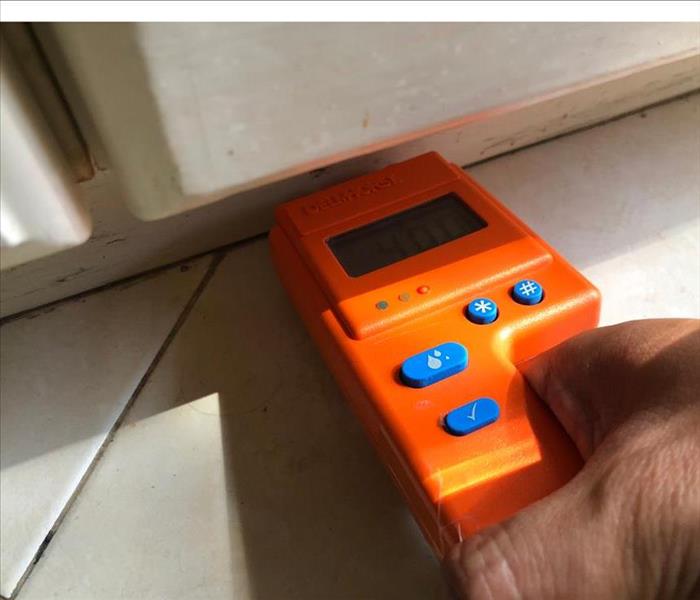 orange moisture meter against wall