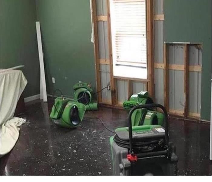 Fans and dehumidifiers placed in a room with water damage