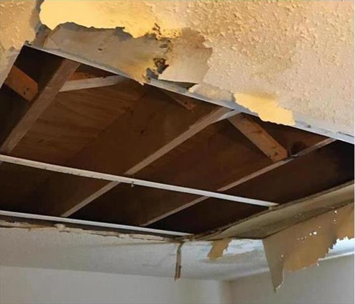 A ceiling with punched holes in it in order to release water after a flood