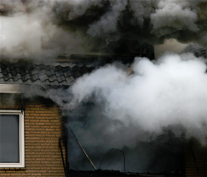 smoke billowing from the windows of a building