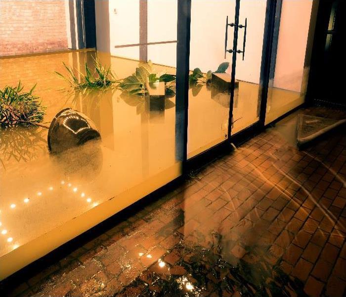 Water flowing through doors from a flooded office.