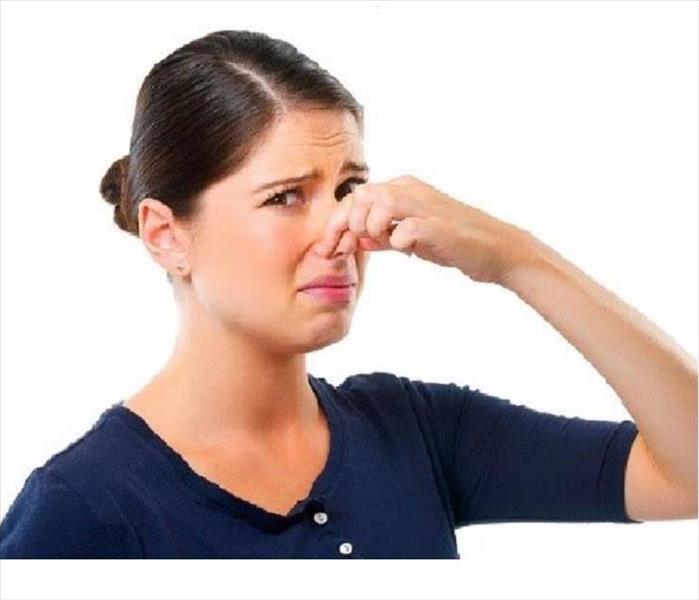 Woman holding nose because of bad smell