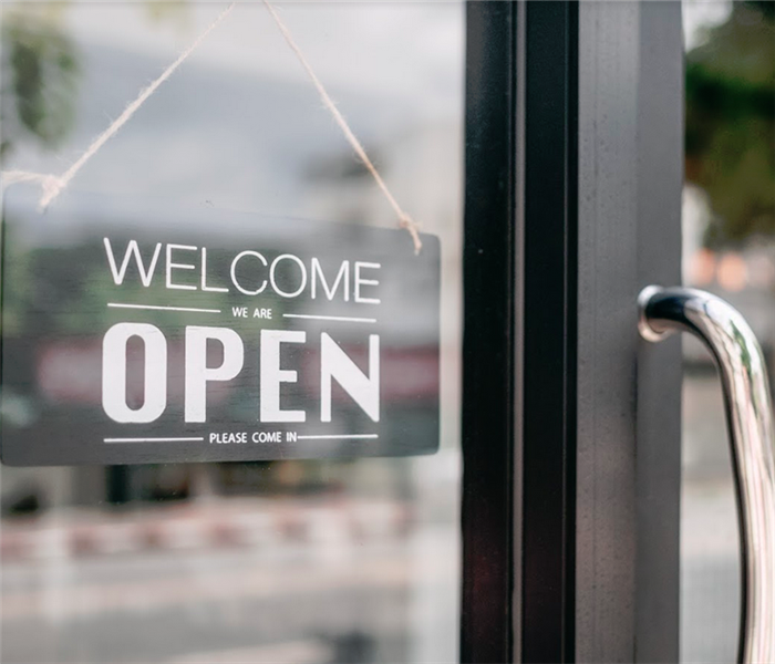 closeup of open and welcome to store sign board at the door