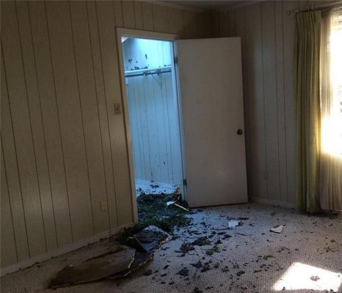 a fire damaged room with soot and debris in the doorway to the closet