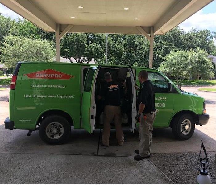 SERVPRO van parked under an awning