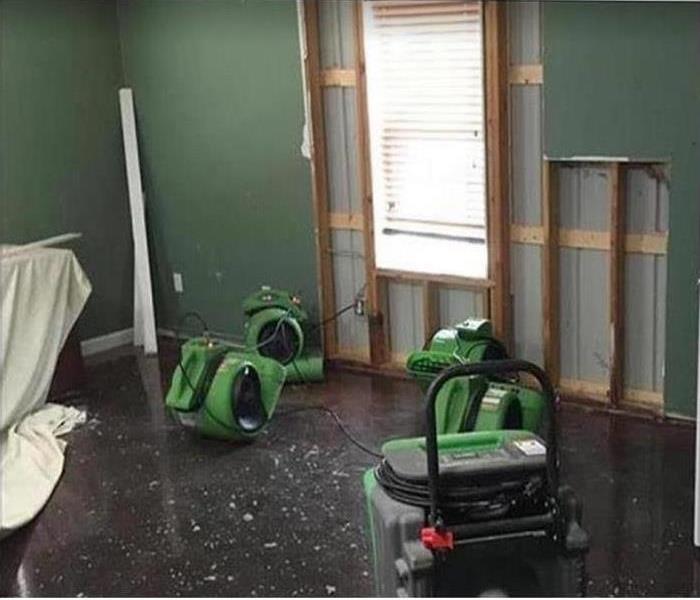 water damaged room; drywall cut away around window; SERVPRO drying equipment being utilized