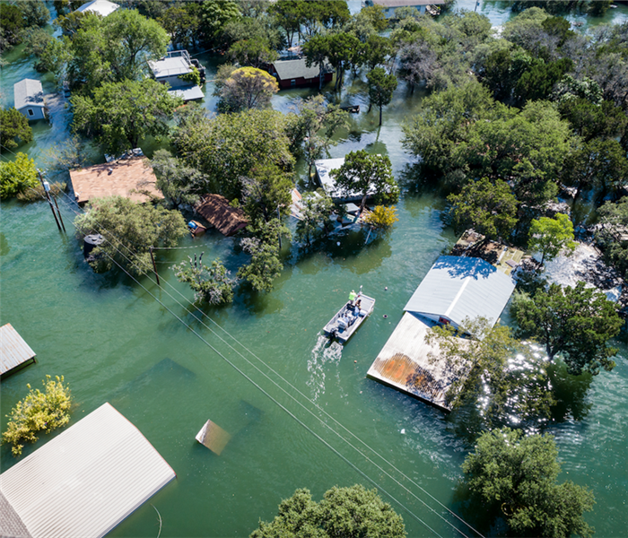 a flooded neighborhood with a rescue boat in the water