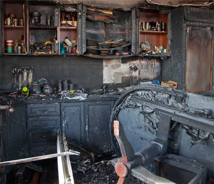 a fire damaged kitchen with soot and debris covering everything